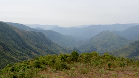 mountain-valley-covered-with-green-forests-and-mists-at-morning-from-flat-angle