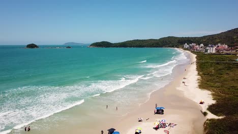 Slowly-drone-shot-of-tourists-bathing-on-a-brazilian-beach