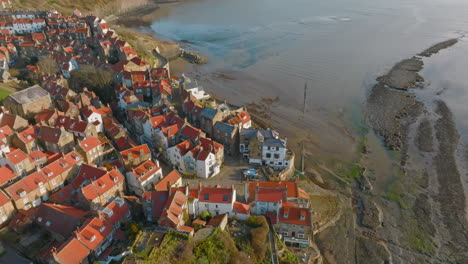 North-York-Moors-Heritage-Coast,-Robin-Hoods-Bay,-Aerial-drone-flight-directly-over-RHB-village-slipway,-pulling-back-tilt-reveal-early-morning-DJI-Mavic-3-Cine-Prores-422-March-2022-Clip-3