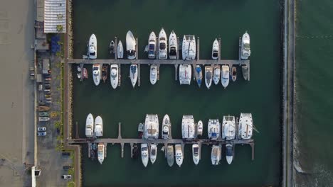 Topdown-drone-video-of-a-marina-where-many-boats-are-docked-or-parked