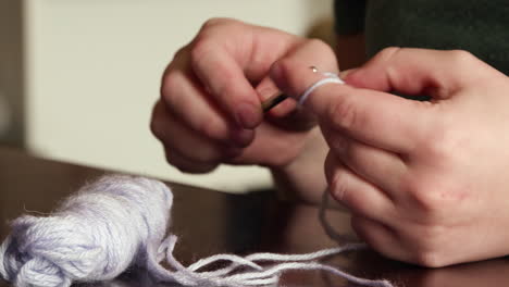 A-close-up-shot-of-caucasian-hands-crocheting-purple-yarn