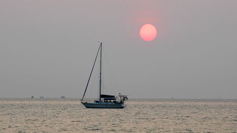 Schöne-Große-Sonne-über-Einer-Yacht-Am-Horizont-Während-Eines-Sonnenuntergangs-In-Bangsaray-Bei-Pattaya-In-Thailand