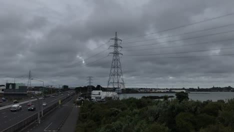 Lapso-De-Tiempo-De-Nubes-De-Tormenta-Moviéndose-Sobre-Postes-Eléctricos-Además-De-Autopista-En-Auckland-Nueva-Zelanda