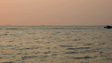 Speed-Boat-Traveling-Fast-on-the-Horizon-with-Pink-Sunset-in-Bangsaray-near-Pattaya,-Thailand