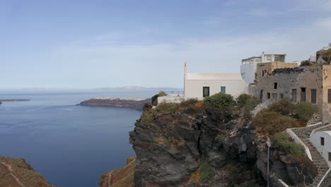 Aerial:-Drone-shot-that-passes-next-to-a-church-in-Imerovigli-of-Santorini-in-the-morning