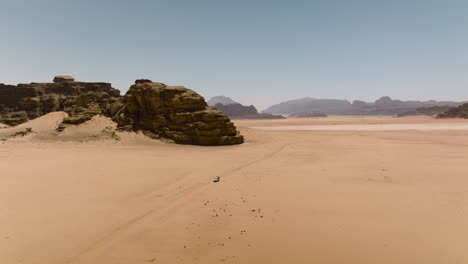 Distant-View-Of-Pick-up-Vehicle-Driving-In-Arid-Desert-Of-Wadi-Rum-In-Jordan