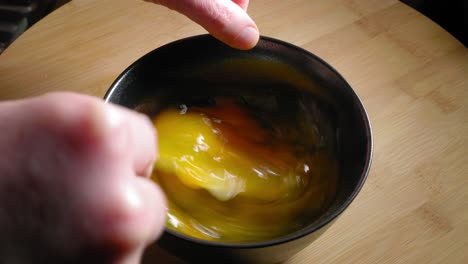 La-Mano-Masculina-Está-Batiendo-Huevos-Con-Un-Tenedor,-Cocinando-Huevos-Para-El-Desayuno
