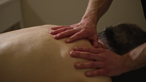 Starke-Masseurhände-Kneten-Und-Massieren-Den-Rücken-Des-Männlichen-Patienten
