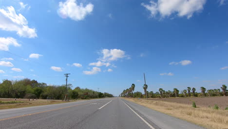 POV-driving-past-the-Santa-Anna-Wildlife-refuge-and-a-palm-date-grove-on-Military-Highway-in-Texas-near-the-international-boarder