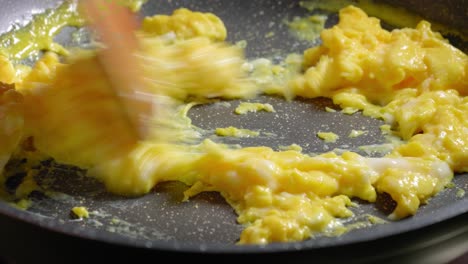 Person-is-Stirring-in-Scrambled-Eggs-on-Frying-Pan,-Cooking-Eggs-for-Breakfast
