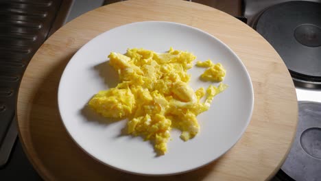 Person-is-Serving-a-Plate-With-Scrambled-Eggs,-Then-Removing-the-Plate
