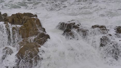Wave-breaking-on-the-rocks-with-white-foam-in-super-slow-motion