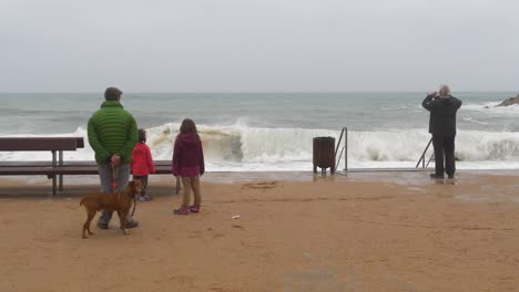 People-from-the-back-watching-the-storm-and-waves-crashing-on-the-beach