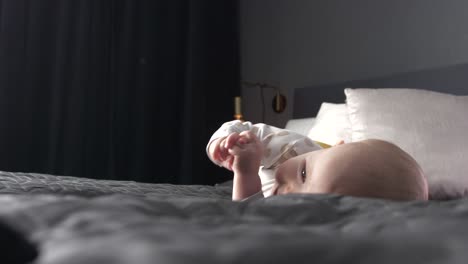 Caucasian-newborn-baby-rolling-on-bed