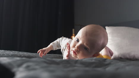 Babymädchen-Auf-Großem-Bett,-Das-Lernt,-Sich-Umzudrehen-Und-Nach-Füßen-Zu-Greifen