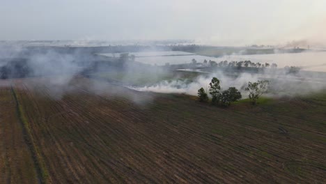 Aerial-reversing-footage-of-a-farmland-burning-in-Pak-Pli,-Nakhon-Nayok,-Thailand
