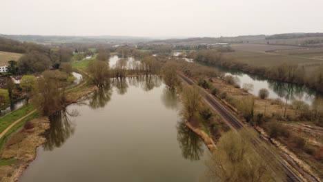 Drohne-Fliegt-über-Seen-In-Der-Nähe-Von-Canterbury-Dies-Sind-Tonford-Seen,-Die-Eine-Bahnstrecke-Zeigen,-Die-Durch-Sie-In-Richtung-Canterbury-Verläuft
