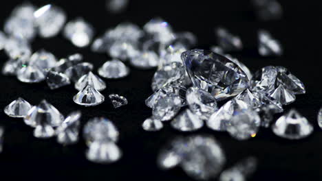 Slow-motion-macro-shot-of-real-glittering-brilliant-cut-various-sized-diamonds-throwing-on-the-black-sorting-table-in-a-jewelry-store-for-further-examination