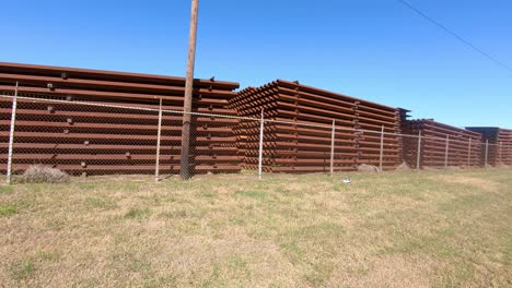 Pov-Pasando-Por-Paneles-Metálicos-Almacenados-Para-Construir-El-Muro-Fronterizo-Entre-Texas,-Ee.uu.-Y-México