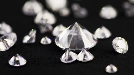 Slow-motion-macro-shot-of-real-brilliant-cut-diamonds-of-various-sizes-falling-down-the-black-sorting-table-in-a-jewelry-store