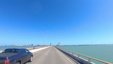 POV-Driving-on-the-Queen-Isabella-Causeway-toward-condo-towers-on-South-Padre-Island-and-past-marshy-area