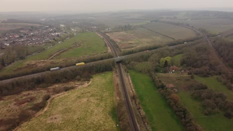 Drone-footage-showing-cars-and-lorries-passing-along-the-A2-dual-carriageway-in-Canterbury-as-it-passes-over-Hambrook-Marshes-and-a-train-track