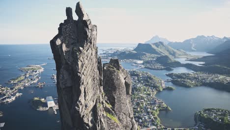 Person-climbing-steep-coastal-cliff-in-Norway,-Lofoten