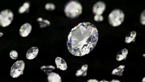 Real-brilliant-cut-shining-diamonds-of-various-sizes-on-the-turntable-rotating-counter-clockwise-shallow-DOF-close-up---highly-valuable-and-expensive-gemstones-for-fashion-and-weddings