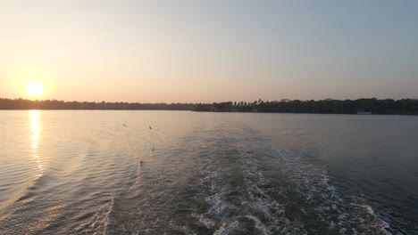 View-from-sailing-boat-of-sunset-on-river-at-Alappuzha-or-Alleppey,-India