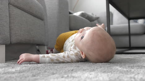 baby-girl-learning-to-roll-over-on-livingroom-carpet