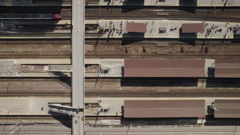 Aerial-top-down-shot-of-the-platforms-on-the-railway-station-Warsaw-West-with-suburban-train-approaching