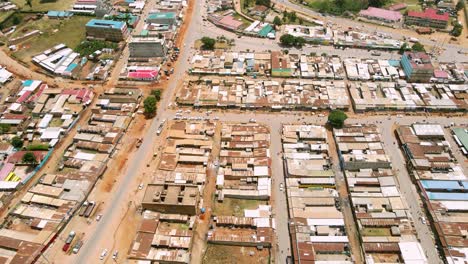 Tilting-drone-flight-of-busy-local-market-in-tribal-village-of-kapenguria,-traditional-rural-community-in-Kenya-Africa