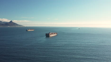 Aerial-View-Of-Cargo-Vessels-With-Shipping-Containers-Traveling-Across-The-Sea-In-Daylight