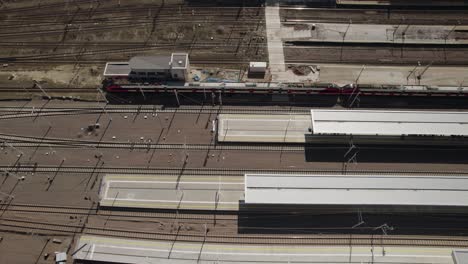 Aerial-trucking-shot-of-the-suburban-train-leaving-Warsaw-West-railway-station-during-refugee-crisis