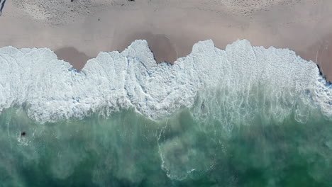 Foamy-Waves-Splashing-On-The-Shore,-Blouberg-Sea-In-Cape-Town,-South-Africa---aerial-top-down