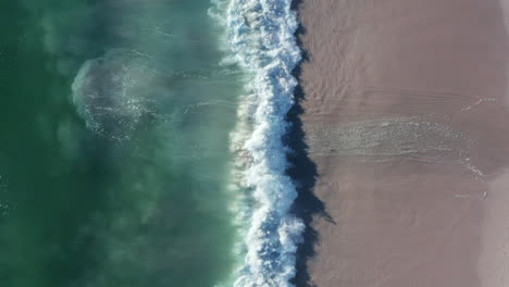 Vertikale-Aufnahme-Des-Blouberg-Meeres-Mit-Schaumigen-Wellen,-Die-An-Der-Küstenlinie-Von-Kapstadt-In-Südafrika-Plätschern