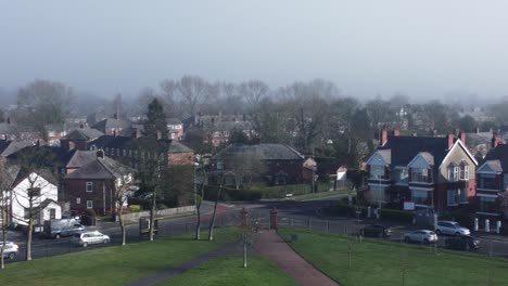 Flying-over-village-residential-neighbourhood-park-on-misty-morning