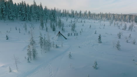Aerial-View-Of-Pyramid-Hut-Near-The-Snowy-Forest-In-Rovaniemi,-Finland