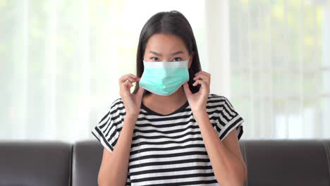 A-very-attractive-young-woman-demonstrates-putting-her-surgical-mask-on