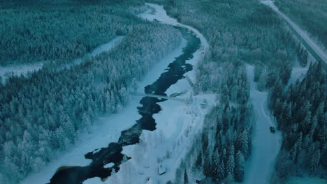 Aerial-View-Of-Vikakongas-River-And-Coniferous-Forest-At-Winter-In-Finland