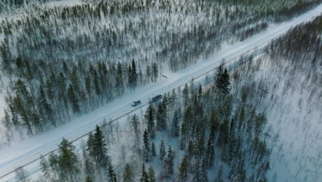 Aerial-Of-Camper-Driving-Through-Winter-Landscapes-In-Lapland,-Finland---drone-shot