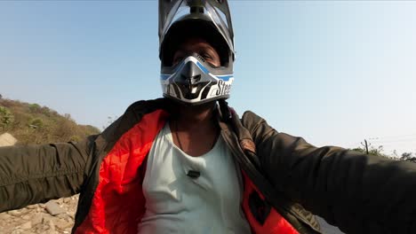 Indischer-Radfahrer-Mit-Jacke,-Der-Motorrad-Auf-Indischem-Straßensporthelm-Mit-Handstunt-Fährt
