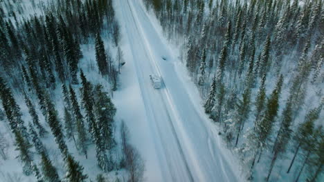 Drone-Sigue-A-Camper-Viajando-Por-Carretera-De-Invierno-En-Laponia,-Finlandia