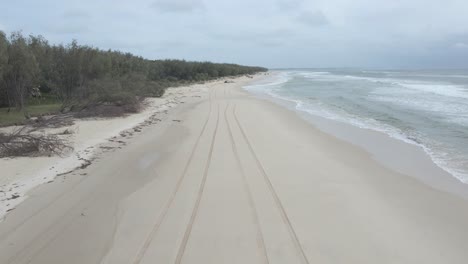 A-Woman-Wearing-Swimsuit-Walking-On-Sandy-Shoreline-In-North-Stradbroke-Island,-Moreton-Bay,-Queensland,-Australia