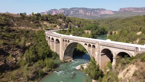 Luftdrohnenansicht-Des-Flusses-Gallego,-Der-Malerischen-Straße-Und-Der-Felsformationen-Mallos-De-Riglos-In-Huesca,-Spanien