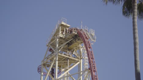 Beautiful-shot-of-a-roller-coaster-gliding-over-the-steep-lift-hill,-and-then-plunging-back-down-towards-earth