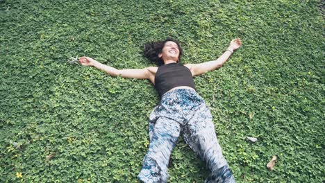 Attractive-fit-woman-enjoys-green-grass-with-bursting-energy,-motion-view