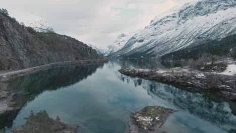 Majestätische-Norwegische-Berglandschaft-Mit-Schneebedeckten-Gipfeln-Und-Kristallklarem-Seewasser,-Lovatnet