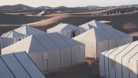 Sahara-camp-of-white-tents-in-hot-Sahara-desert,-handheld-motion-view