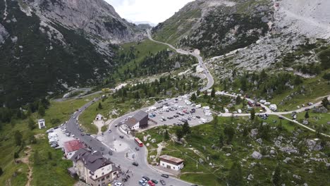 Falzarego-Mountain-Pass-at-Veneto,-Belluno,-Italian-Alps,-Italy---Aerial-Drone-View-of-the-Parking-Lot,-Driving-Cars-and-Dolomites-Road
